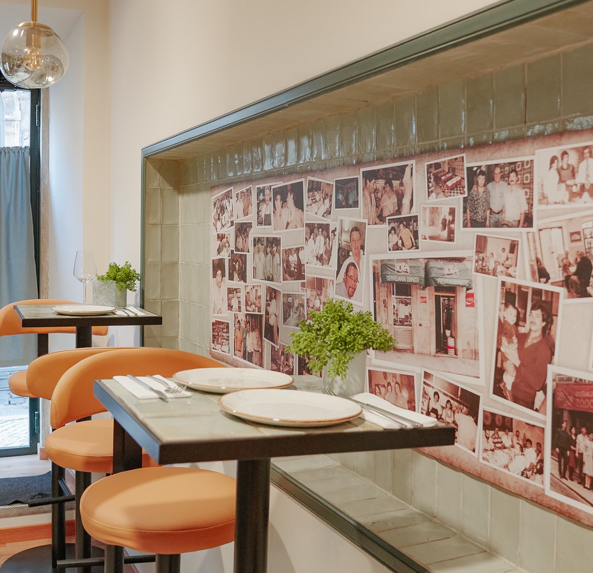 Salle aux tables dressées et mur couvert de photos de famille
